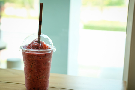mixed berries smoothie on wood table near window. delicious blended yogurt beverage with blueberry, raspberry & strawberry. healthy dessert for summerの写真素材