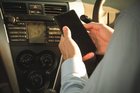 businessman use app on smartphone in car. caucasian man holding mobile phone checking direction...