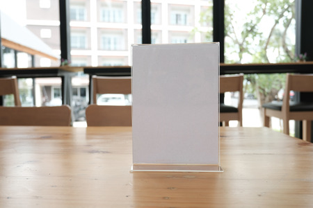 white label in cafe. display stand for acrylic tent card in coffee shop. mockup menu frame on table in bar restaurant. space for textの写真素材
