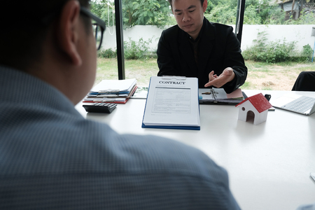 real estate agent have a meeting with customer. sale & purchase property with house model signing contract document. realtor talk with client.の写真素材