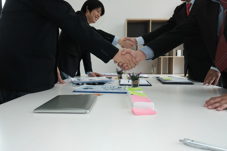 Business people shaking hands after finishing up a meeting. Two colleagues handshaking after conference. Greeting deal, teamwork, partnership, corporate concept.の写真素材