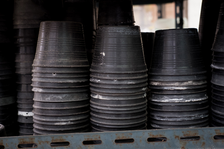 old black plastic plant pot on shelfの写真素材