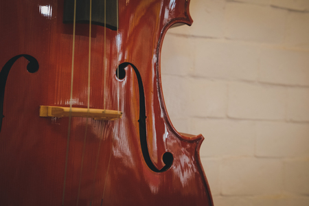 brown cello near red wall. musical instrumentの写真素材