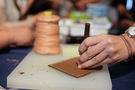 craftsman pinching button on leather bag. handmade DIY handicraft workshop