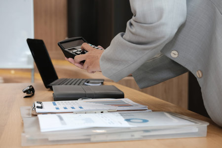 financial adviser working with calculator at office. accountant doing accounting & calculating...