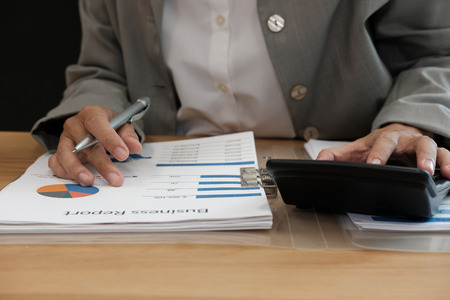 financial adviser working with calculator, business document at office. accountant doing accounting & calculating revenue & budget. bookkeeper making calculation. finance & economy conceptの写真素材
