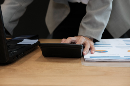 financial adviser working with calculator, business document at office. accountant doing accounting & calculating revenue & budget. bookkeeper making calculation. finance & economy conceptの写真素材