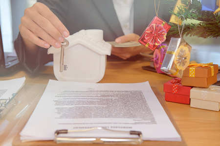 house agent with house model banknote & key. buying selling renting real estate propertyの写真素材