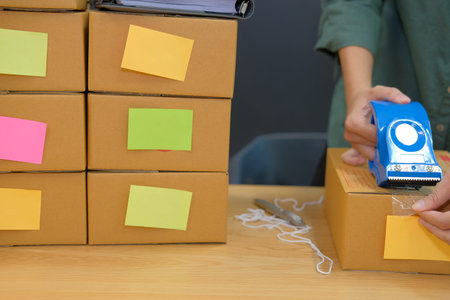 startup small business owner packing cardboard box at workplace. freelance woman entrepreneur seller...
