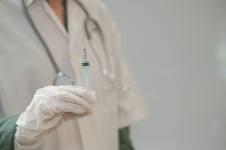 doctor physician medical practitioner with syringe for vaccine injection at clinic hospitalの写真素材