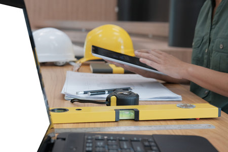architect using tablet. engineer working on house blueprint of real estate project at workplace....