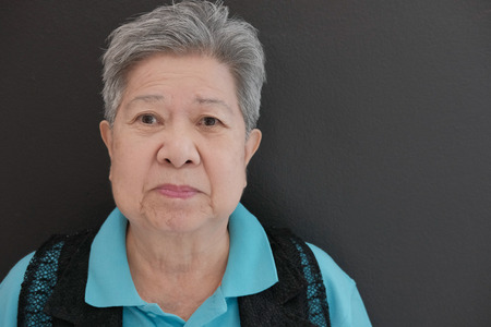 happy old elderly elder senior woman smiling with happiness near black wallの写真素材