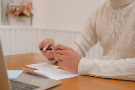 man wearing cream sweater writing christmas letter greeting card holiday wishes. xmas celebration.の写真素材