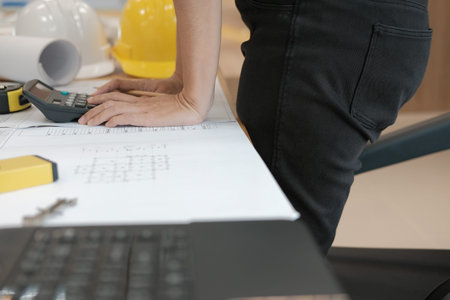 architect working on house blueprint of real estate project at workplace. engineer using calculator....