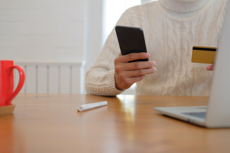 man holding credit card & smart phone for online shopping.  male buyer buying or make payment on internet.の写真素材
