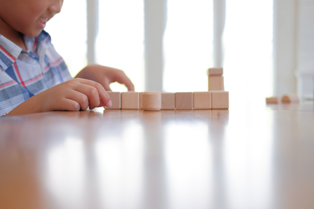 young little asian kid boy child children schoolboy playing wood block toy. learning education conceptの写真素材