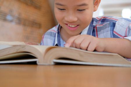 young little asian kid boy child children schoolboy studying reading book. childhood education