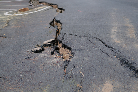 cracks on asphault rural road. damaged collapsed streetの写真素材