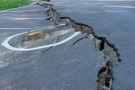cracks on asphault rural road. damaged collapsed streetの写真素材