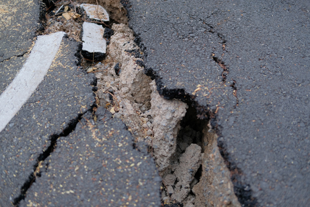 cracks on asphault rural road. damaged collapsed streetの写真素材