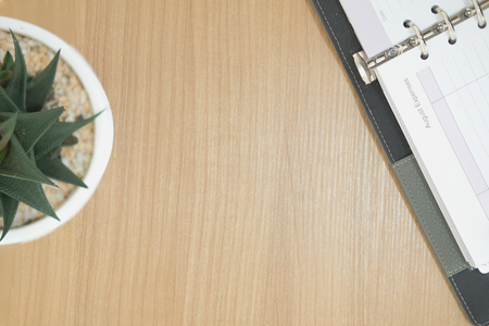 notebook on wooden desk table. office workplace workspace top view. succulent cactus plant in pot. education conceptの写真素材