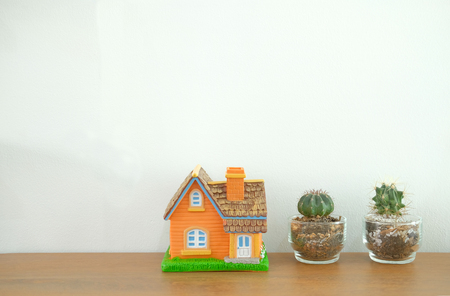 house model on wooden desk near white wall. realtor real estate agent workplace. buying selling & renting propertyの写真素材