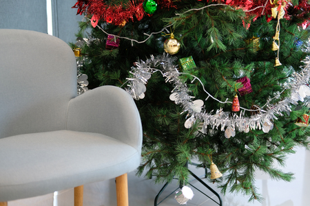 decorated christmas tree & gray chair in living room. xmas holiday celebration in decemberの写真素材