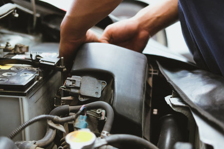 mechanic changing air filter for car in automobile repair service. automotive spare part checkup in...