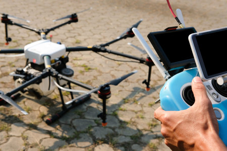 man controlling agriculture drone at farm. remote controller
