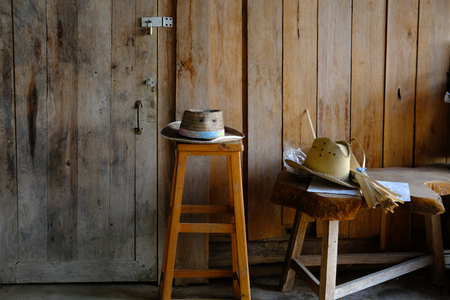 wicker rattan hat on wooden stool at rural country houseの写真素材