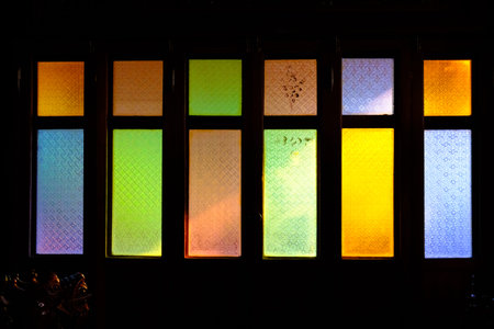 colorful stained glass window of wooden house with morning light