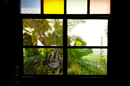 colorful stained glass window of wooden house with garden view backgroundの写真素材