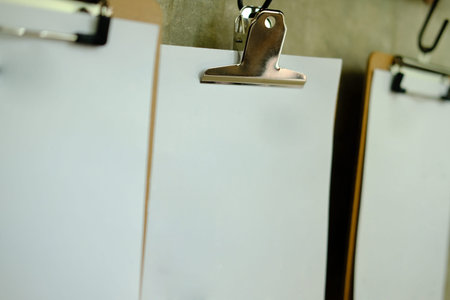 blank white paper poster menu hanging on gray wall