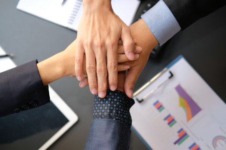 businessman joining united hand, business team touching hands together after complete a deal in...