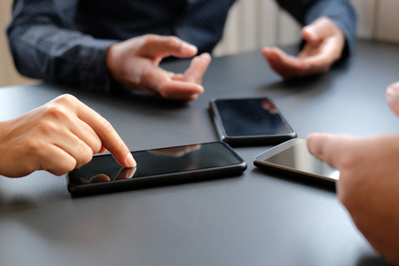 business people discussing using smart mobile phone smartphoneの写真素材