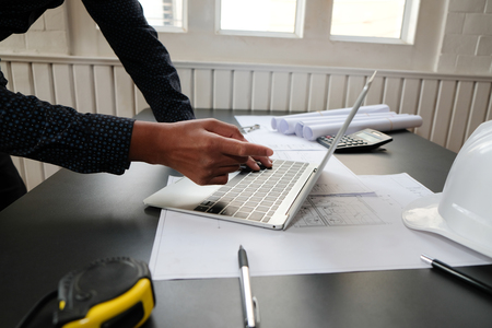 architect engineer working on house blueprint of real estate project at workplace. building construction conceptの写真素材