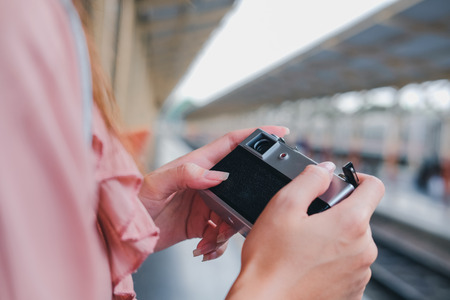 woman traveler holding camera taking photo at train station. travel trip journey conceptの写真素材