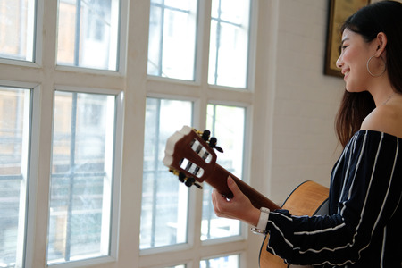 woman playing guitar at home.  leisure lifestyle conceptの写真素材