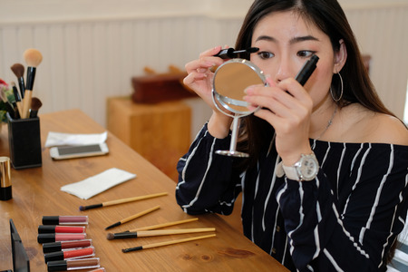 asian woman applying makeup cosmetic. make up beauty conceptの写真素材