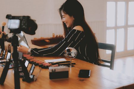 beauty blogger live broadcasting cosmetic makeup tutorial on social media. vlogger recording vlog video. influencer marketingの写真素材