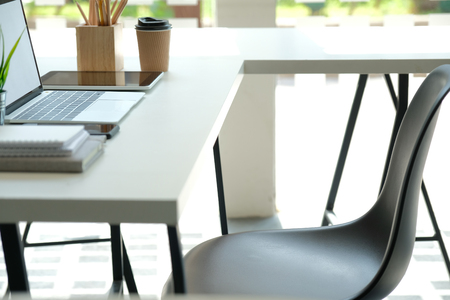 computer tablet pencil coffee cup on office desk. workplace co-working space interiorの写真素材