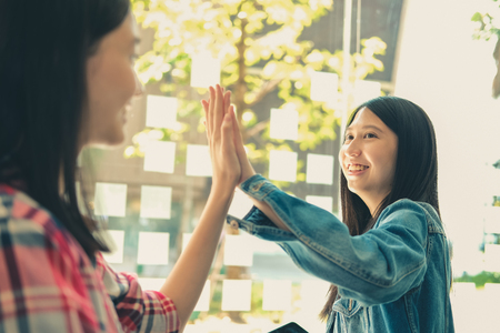 girl teenager giving high five touching hands together. teamwork friendship amity conceptの写真素材