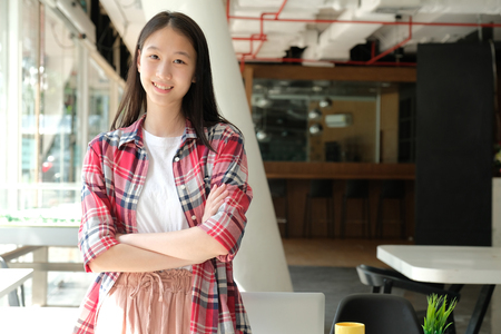 asian teenage girl teenager posing at co-working spaceの写真素材