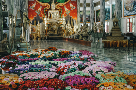 Ubonratchatani, Thailand - July 10, 2019: golden buddha image statue & flower candle in Phra that Nongbua temple in Ubonratchatani, Thailand on July 9, 2019:のeditorial素材