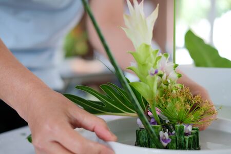 florist arranging flower bouquet in vase. people in floristry class course workshopの写真素材