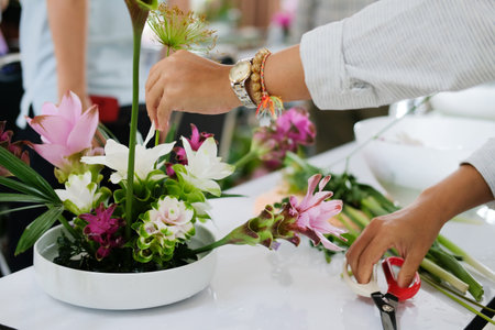 florist arranging flower bouquet in vase. people in floristry class course workshop