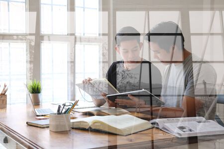 designer working on graphic tablet discussing creative idea of startup project with partnerの写真素材