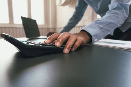 financial adviser working with calculator at office. accountant doing accounting & calculating revenue & budget. bookkeeper making calculation. finance & economy conceptの写真素材