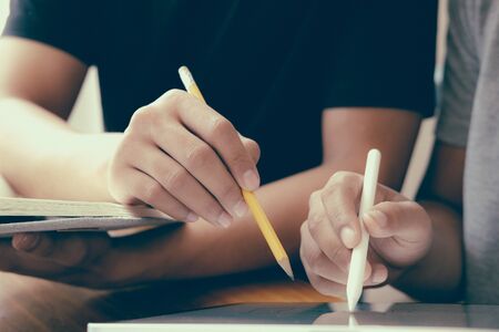 designer working on graphic tablet discussing creative idea of startup project with partnerの写真素材