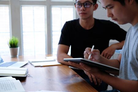designer working on graphic tablet discussing creative idea of startup project with partnerの写真素材